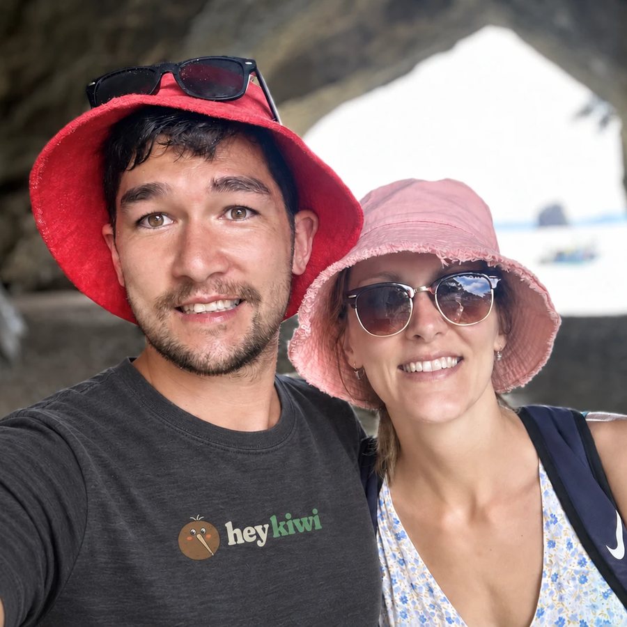 Joshua and Lena, the family behind Hey Kiwi, in sun hats on a New Zealand beach
